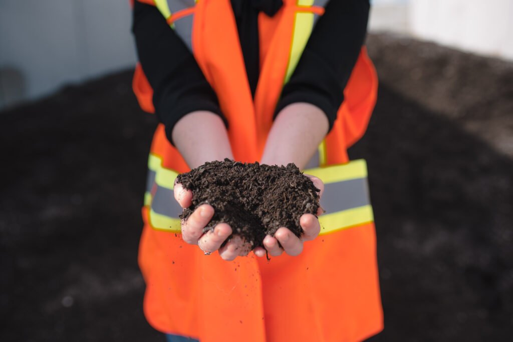 A worker holding a handful of mulch. 