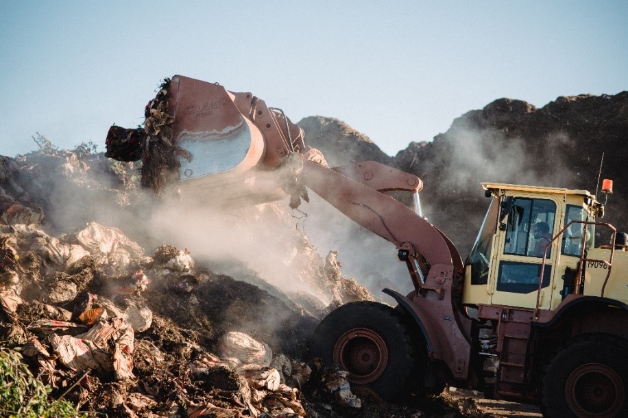 A bulldozer transports bags of yard waste in a Miller Compost facility.
