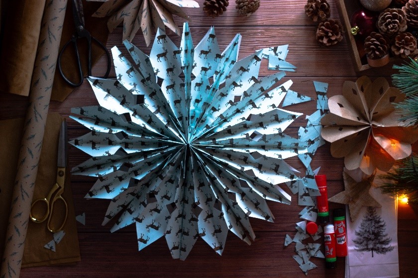 A blue paper snowflake with a deer print. 