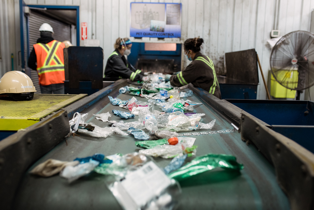 Miller Waste employees sorting through recyclable materials on a belt.